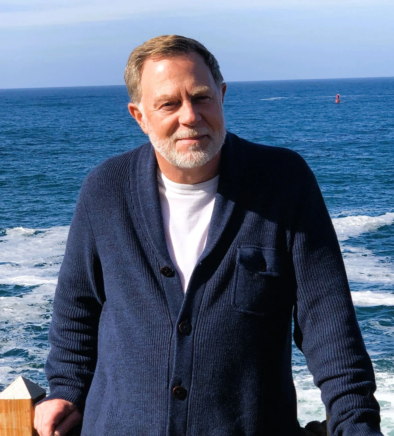 A man standing on the beach near the ocean.